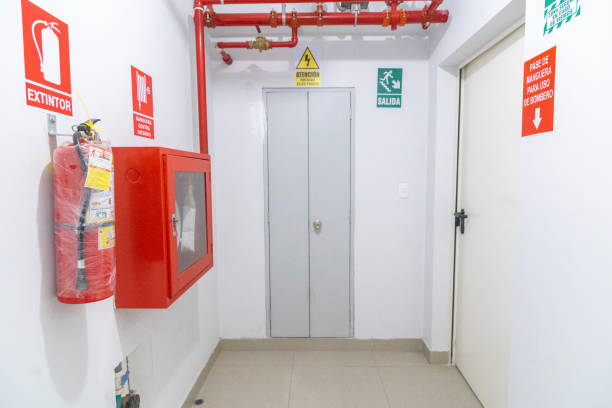 Pasillo con sectorización contra incendios: puertas cortafuegos RF, boca de incendio equipada (BIE) y extintor señalizados según normativa CTE DB-SI