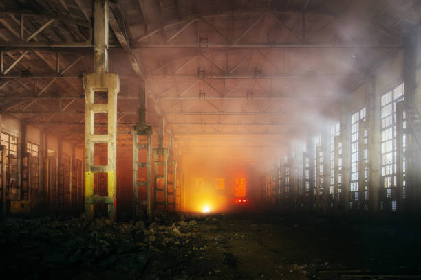 Interior de nave industrial en llamas con humo y pilares estructurales sin protección ignífuga
